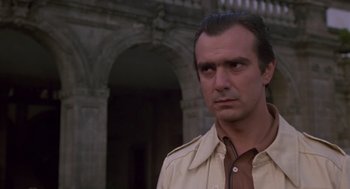 Movie still from “The Falcon and the Snowman” (1985), directed by John Schlesinger – A person wearing a trench coat; Close Up shot, Low angle