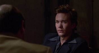 Movie still from “The Falcon and the Snowman” (1985), directed by John Schlesinger – A man in a black jacket is looking at a man in a brown shirt; Close Up shot, Over the shoulder angle