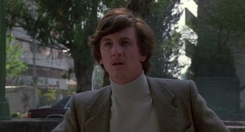 Movie still from “The Falcon and the Snowman” (1985), directed by John Schlesinger – A man with long hair wearing a suit and tie; Close Up shot, Low angle