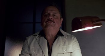 Movie still from “The Falcon and the Snowman” (1985), directed by John Schlesinger – An older man wearing a white shirt and a white jacket; Close Up shot, Low angle