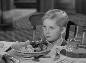 Movie still from “The Fallen Idol” (1948), directed by Carol Reed – A boy sitting at a table with a plate of food; Close Up shot, High angle