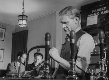 Movie still from “The Fallen Idol” (1948), directed by Carol Reed – An old black and white photo of a man in a bar; Medium shot, Low angle