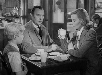 Movie still from “The Fallen Idol” (1948), directed by Carol Reed – An old photo of a family sitting at a table drinking coffee; Medium shot, High angle
