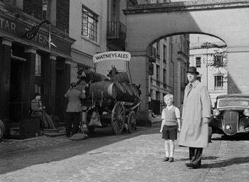 Movie still from “The Fallen Idol” (1948), directed by Carol Reed – An old black and white photo of two men and a horse drawn carriage; Wide shot, High angle