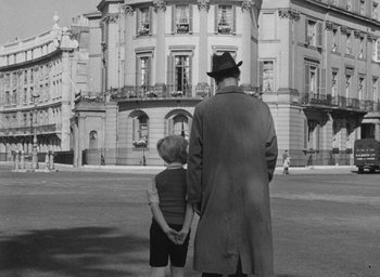 Movie still from “The Fallen Idol” (1948), directed by Carol Reed – An older man and a young boy standing in front of a building; Wide shot, Low angle