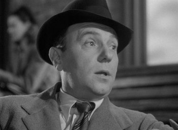 Movie still from “The Fallen Idol” (1948), directed by Carol Reed – A man wearing a suit and a hat looking to his left; Close Up shot, Low angle