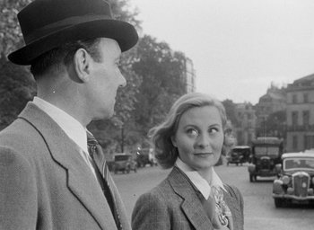 Movie still from “The Fallen Idol” (1948), directed by Carol Reed – A man and a woman standing next to each other on the street; Medium shot, Over the shoulder angle