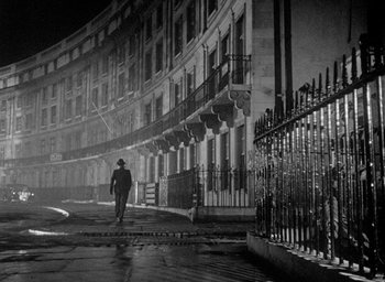 Movie still from “The Fallen Idol” (1948), directed by Carol Reed – A man walking down the street in the rain; Extreme Wide shot, Low angle