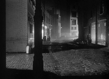 Movie still from “The Fallen Idol” (1948), directed by Carol Reed – A black - and - white photo of a city street at night; Extreme Wide shot, High angle