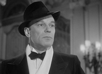 Movie still from “The Fallen Idol” (1948), directed by Carol Reed – A man wearing a suit and a hat looking to his left; Close Up shot, Low angle
