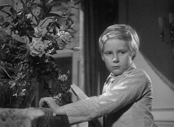 Movie still from “The Fallen Idol” (1948), directed by Carol Reed – A young boy holding a knife near a plant; Close Up shot, Over the shoulder angle