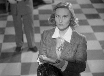 Movie still from “The Fallen Idol” (1948), directed by Carol Reed – A black and white photo of a woman in a suit; Medium shot, Over the shoulder angle