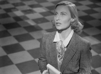 Movie still from “The Fallen Idol” (1948), directed by Carol Reed – An old photo of a woman in a suit holding a book; Close Up shot, Low angle