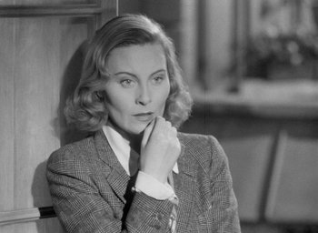 Movie still from “The Fallen Idol” (1948), directed by Carol Reed – An old photo of a woman in a suit looking at the camera; Close Up shot, Over the shoulder angle