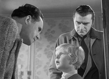 Movie still from “The Fallen Idol” (1948), directed by Carol Reed – Two men and a boy are looking at each other; Medium shot, Over the shoulder angle