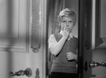 Movie still from “The Fallen Idol” (1948), directed by Carol Reed – A young boy standing next to a door; Medium shot, High angle