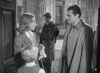 Movie still from “The Fallen Idol” (1948), directed by Carol Reed – A man and a woman talking to a boy; Medium shot, Over the shoulder angle