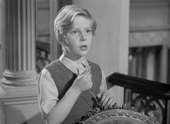 Movie still from “The Fallen Idol” (1948), directed by Carol Reed – A young boy is holding a tie in his hand; Medium shot, High angle
