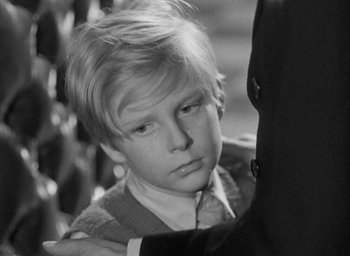Movie still from “The Fallen Idol” (1948), directed by Carol Reed – A young boy is looking down at his father's shoulder; Close Up shot, Over the shoulder angle