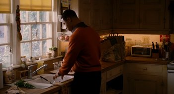Movie still from “The Family Stone” (2005), directed by Thomas Bezucha – A man standing at a sink in a kitchen preparing a meal; Medium shot, High angle