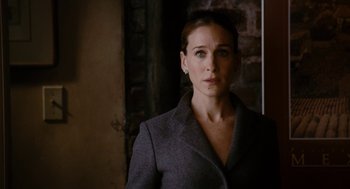 Movie still from “The Family Stone” (2005), directed by Thomas Bezucha – A woman in a gray suit standing in front of a brick wall; Close Up shot, Over the shoulder angle