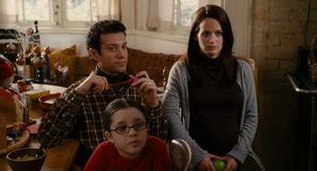 Movie still from “The Family Stone” (2005), directed by Thomas Bezucha – A man and a woman sitting next to a child; Medium shot, Over the shoulder angle