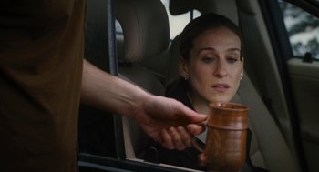 Movie still from “The Family Stone” (2005), directed by Thomas Bezucha – A woman sitting in the back of a car holding a cup; Close Up shot, Over the shoulder angle