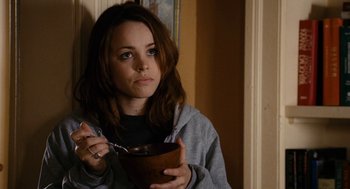 Movie still from “The Family Stone” (2005), directed by Thomas Bezucha – A woman holding a bowl of food while sitting in a room; Close Up shot, High angle