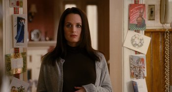 Movie still from “The Family Stone” (2005), directed by Thomas Bezucha – A woman standing in a room wearing a black shirt; Close Up shot, Over the shoulder angle