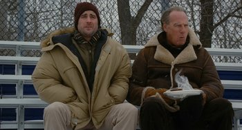 Movie still from “The Family Stone” (2005), directed by Thomas Bezucha – Two men are sitting on a park bench; Medium shot, Low angle