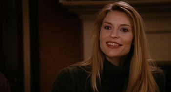 Movie still from “The Family Stone” (2005), directed by Thomas Bezucha – A woman smiles for the camera while posing for a picture; Close Up shot, Over the shoulder angle