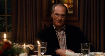 Movie still from “The Family Stone” (2005), directed by Thomas Bezucha – A man sitting at a dinner table with candles; Medium shot, Over the shoulder angle