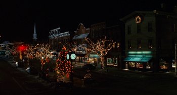 Movie still from “The Family Stone” (2005), directed by Thomas Bezucha – A christmas tree is lit up in a town square at night; Extreme Wide shot, High angle