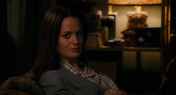 Movie still from “The Family Stone” (2005), directed by Thomas Bezucha – A woman sitting in a chair in a dark room; Close Up shot, Over the shoulder angle