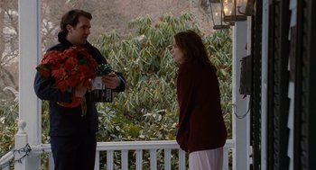 Movie still from “The Family Stone” (2005), directed by Thomas Bezucha – A man and a woman standing next to each other on a porch; Medium shot, Over the shoulder angle
