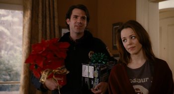 Movie still from “The Family Stone” (2005), directed by Thomas Bezucha – A man and a woman holding presents in a room; Medium shot, Over the shoulder angle