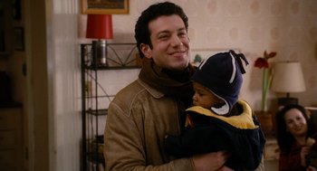 Movie still from “The Family Stone” (2005), directed by Thomas Bezucha – A man holding a child in his arms; Close Up shot, High angle