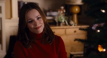 Movie still from “The Family Stone” (2005), directed by Thomas Bezucha – A woman in a red sweater smiling for the camera; Close Up shot, Over the shoulder angle