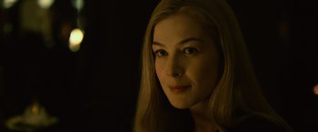 Movie still from “Gone Girl” (2014), directed by David Fincher – A woman with long blonde hair is smiling for the camera; Close Up shot, Over the shoulder angle