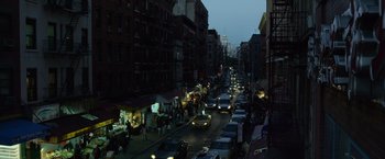 Movie still from “Gone Girl” (2014), directed by David Fincher – A busy city street at night with cars parked on the side of the road; Extreme Wide shot, High angle