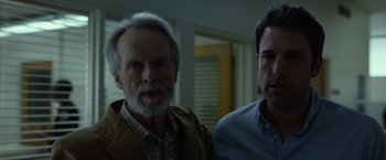 Movie still from “Gone Girl” (2014), directed by David Fincher – Two men standing next to each other in front of a window; Close Up shot, Over the shoulder angle