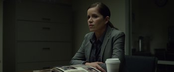 Movie still from “Gone Girl” (2014), directed by David Fincher – A woman sitting at a table in front of a coffee cup; Medium shot, Over the shoulder angle