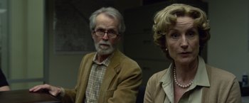 Movie still from “Gone Girl” (2014), directed by David Fincher – An older man and a younger woman are standing side by side; Close Up shot, Over the shoulder angle