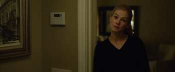 Movie still from “Gone Girl” (2014), directed by David Fincher – A woman standing next to a wall in front of a mirror; Close Up shot, Over the shoulder angle