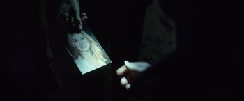 Movie still from “Gone Girl” (2014), directed by David Fincher – A person holding a picture of a woman in a dark room; Extreme Close Up shot, Over the shoulder angle