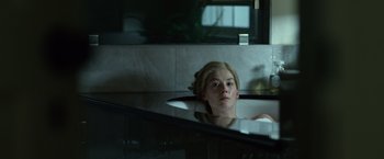 Movie still from “Gone Girl” (2014), directed by David Fincher – A woman sitting in a sink in front of a bathroom mirror; Medium shot, High angle