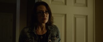 Movie still from “Gone Girl” (2014), directed by David Fincher – A person wearing glasses and a jean jacket; Close Up shot, Over the shoulder angle