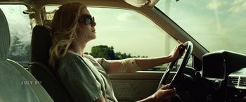 Movie still from “Gone Girl” (2014), directed by David Fincher – A woman sitting in the drivers seat of a car; Medium shot, Low angle