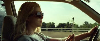 Movie still from “Gone Girl” (2014), directed by David Fincher – A woman driving a car on a road; Close Up shot, Low angle