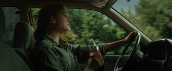 Movie still from “Gone Girl” (2014), directed by David Fincher – A woman sitting in the drivers seat of a car; Medium shot, Over the shoulder angle